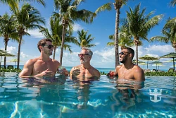 Adults relaxing beside a Royal Caribbean pool and wellness area